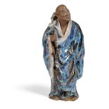 FLAMBE-GLAZED SHIWAN POTTERY FIGURE OF A MONK LATE QING DYNASTY-REPUBLIC PERIOD, 19TH-20TH CENTURY