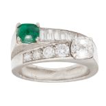 An emerald and diamond set cross-over ring