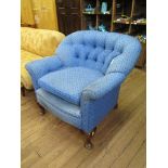 A 1920s blue button back upholstered arm chair with cabriole legs and pad feet