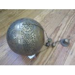 A Moroccan style pierced brass pendant light shade, of globular form, 21 cm diameter