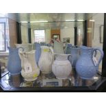 Ten Victorian stoneware relief moulded jugs, including three in blue with anthemion design 19 cm