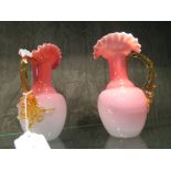 A pair of Victorian pink and white cased glass ewer vases with uranium colour glass handles, 16.