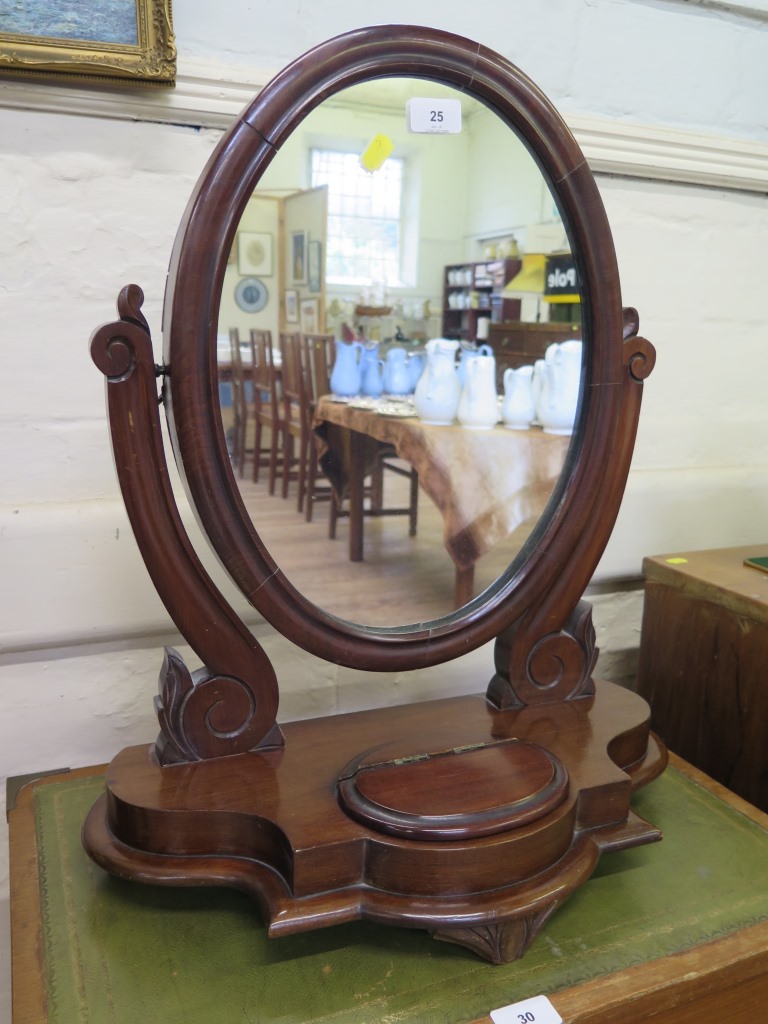 A Victorian mahogany toilet mirror, the oval plate within scroll supports and shaped base with