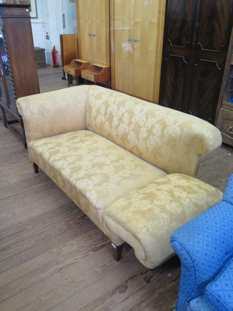 An Edwardian upholstered two seat sofa, with drop arm and square tapering legs, 151 cm long