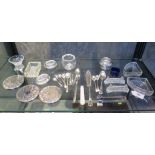 Three circular silver plate mats, sugar tongs, salt spoons, knives, two glass knife-rests and