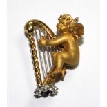 A pendant in the form of a cherub playing a harp, marked 750