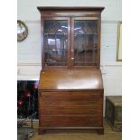 A George III mahogany bureau bookcase, with ogee arched glazed doors, over a sloping front enclosing