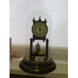 An early 20th century brass anniversary clock, with rotating pendulum and glass dome, 29 cm high