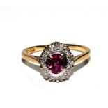 A ruby and diamond cluster ring set in 18 carat yellow gold