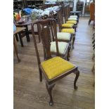 A set of eight Queen Anne style dining chairs, with foliate carved solid splats above drop-in