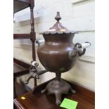A late Victorian copper table top urn, with glass twin handles and tap, on four scroll feet, 48 cm
