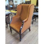 An early Victorian mahogany wing armchair, with turned tapering legs