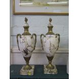 A pair of white marble and giltmetal vases, with domed covers and entwined serpent handles on square