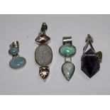 A collection of four silver and gem set pendants