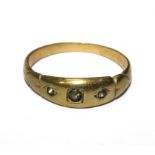 A yellow metal ring set with three paste stones