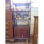 A mid 19th century mahogany whatnot, the four tiers over a pair of cupboard doors, on turned legs