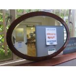 An Edwardian walnut line inlaid oval mirror, with bevelled plate, 102.5 x 71.5 cm