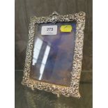 A silver photograph frame decorated in high relief, 12cm x 16cm