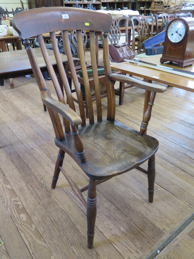 An ash and elm rail back kitchen armchair, with ring turned tapering legs joined by a stretcher