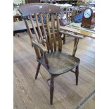 An ash and elm rail back kitchen armchair, with ring turned tapering legs joined by a stretcher