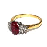 An 18 carat gold ring having a red stone to centre with three diamonds either side