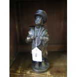 A bronze finish figure of a young boy dressed in military clothing with binoculars around his