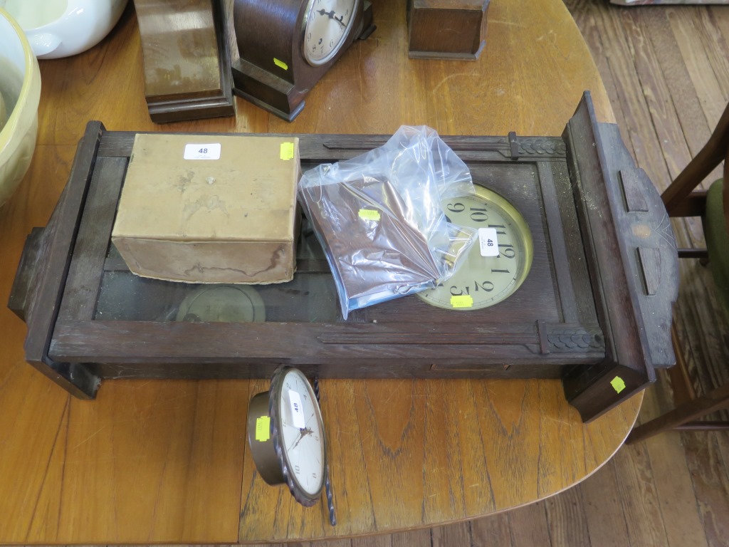 A 1930s oak cased wall clock, as found, 82 cm high, a 1940s brass table clock, a twin train spring