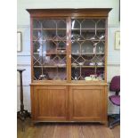 A George III mahogany bookcase cabinet, the moulded top over a pair of astragal glazed doors,