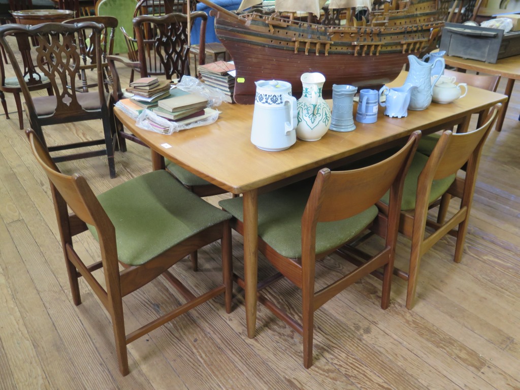 A set of six 1970s teak dining chairs, with broad top rails and padded seats, on turned legs, and