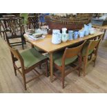 A set of six 1970s teak dining chairs, with broad top rails and padded seats, on turned legs, and