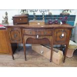 A Regency style crossbanded mahogany serpentine sideboard, the two central drawers flanked by a