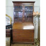 A George III mahogany bureau bookcase, with ogee arched glazed doors, over a sloping front enclosing