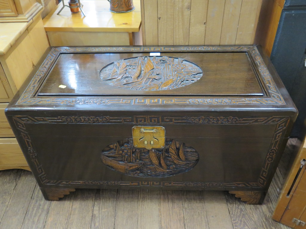 A Chinese camphorwood carved chest, of rectangular form, carved with junks, 88 cm wide, 42.5 cm