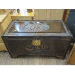 A Chinese camphorwood carved chest, of rectangular form, carved with junks, 88 cm wide, 42.5 cm