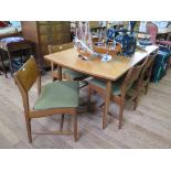 A set of six 1970s teak dining chairs, with broad top rails and padded seats, on turned legs, and