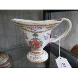 A Chinese export style jug, with entwined handle, enamelled floral sprays and coat of arms, 13 cm