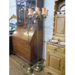A brass six light standard lamp, the scroll arms on a reeded column, with circular base and paw