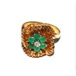 A gold colour metal ring set with green stones