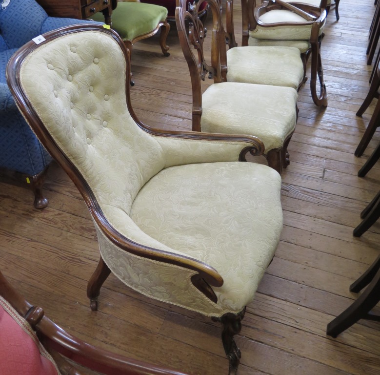 A Victorian walnut nursing chair with cream button upholstery, on cabriole legs and pot castors