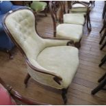 A Victorian walnut nursing chair with cream button upholstery, on cabriole legs and pot castors