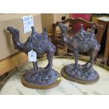 A pair of bronze effect resin figures of saddled camels, 27 cm high