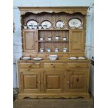 A pine dresser and rack, the rack with cupboard doors and drawers, the dresser with three frieze