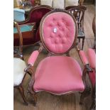 A Victorian walnut gentleman's armchair, the oval button back with floral carved top rail and scroll
