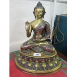 A bronze figure of a seated Buddha, hand raised, on a lotus leaf base, 35 cm high