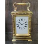 A gilt brass carriage clock, with foliate fluted columns and cream enamelled dial, the twin train