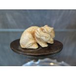A Japanese ivory carving on stand of an angry foo dog, 4.5 cm long