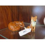 A Beswick curled lying fox, model 1017 and a Beswick small seated fox, model 1748