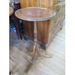 A George III style mahogany and beech tripod wine table, the circular top with inlaid edge on a
