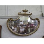 A Neo-Classical style shield shape parcel gilt wall mirror, surmounted by urn and garlands over a
