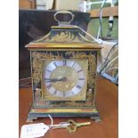 A 1920s Chinoserie design lacquered table timepiece clock, with caddy top over a brass dial with